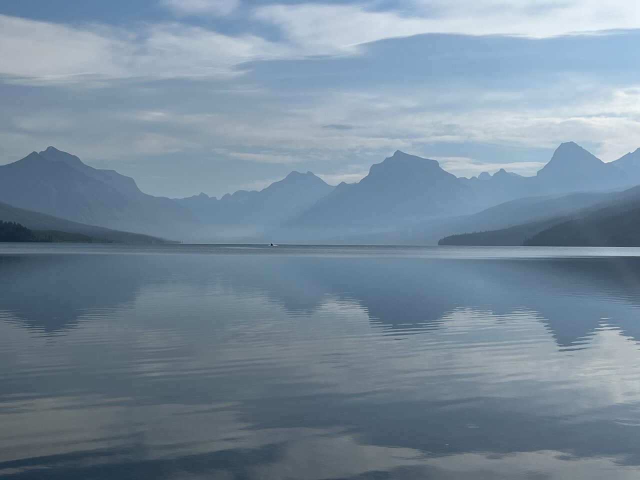 Lake McDonald and McDonald Creek in Glacier National Park, photographed from the water in July 2026