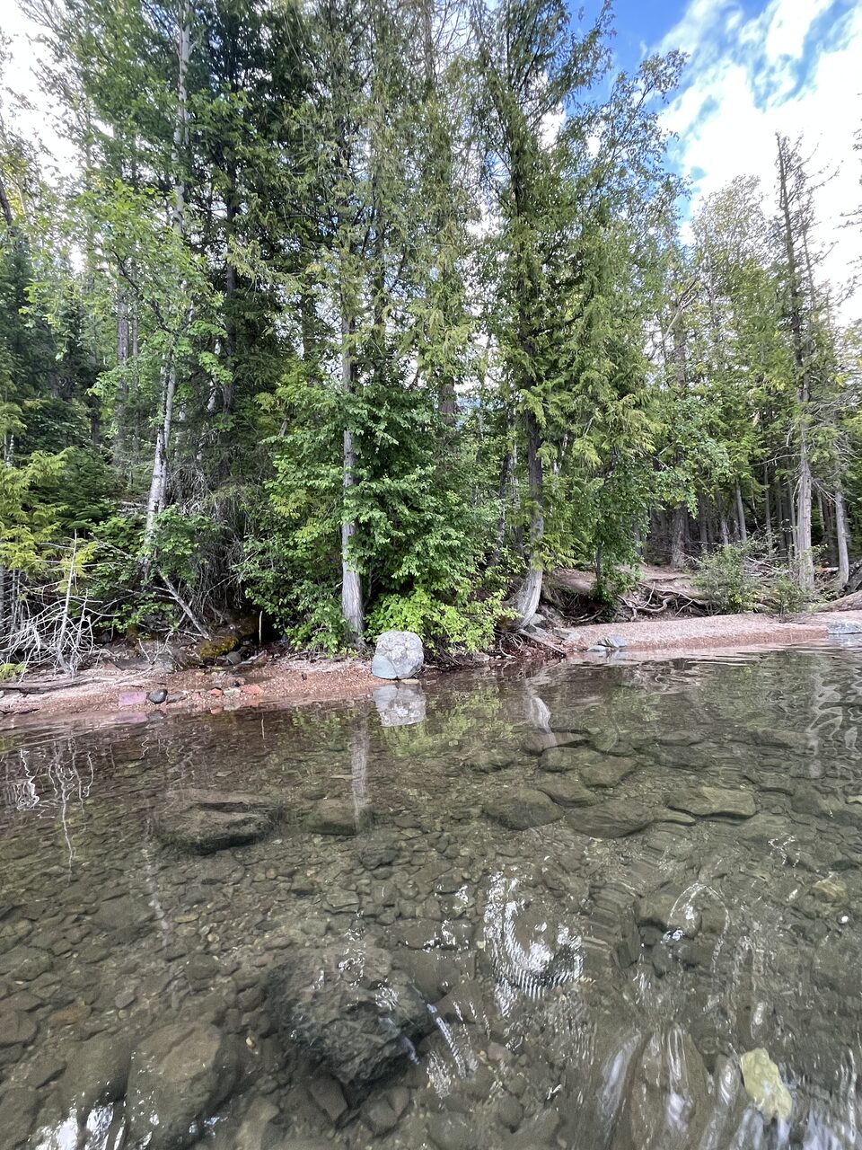 Lake McDonald and McDonald Creek in Glacier National Park, photographed from the water in July 2026