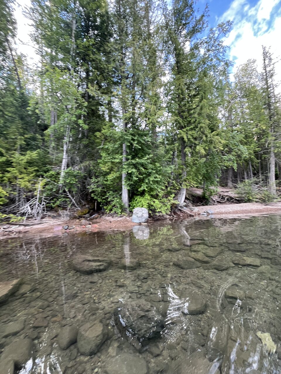 Lake McDonald and McDonald Creek in Glacier National Park, photographed from the water in July 2026
