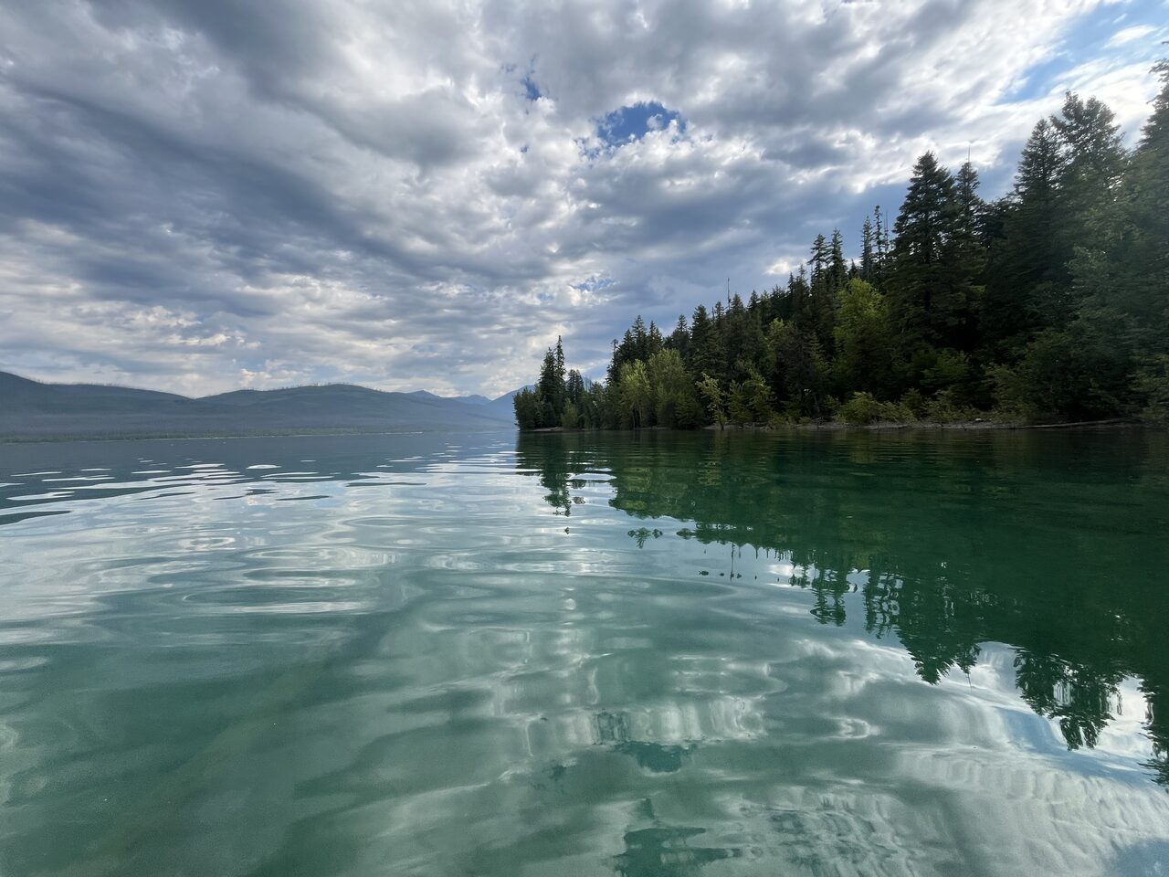Lake McDonald and McDonald Creek in Glacier National Park, photographed from the water in July 2026