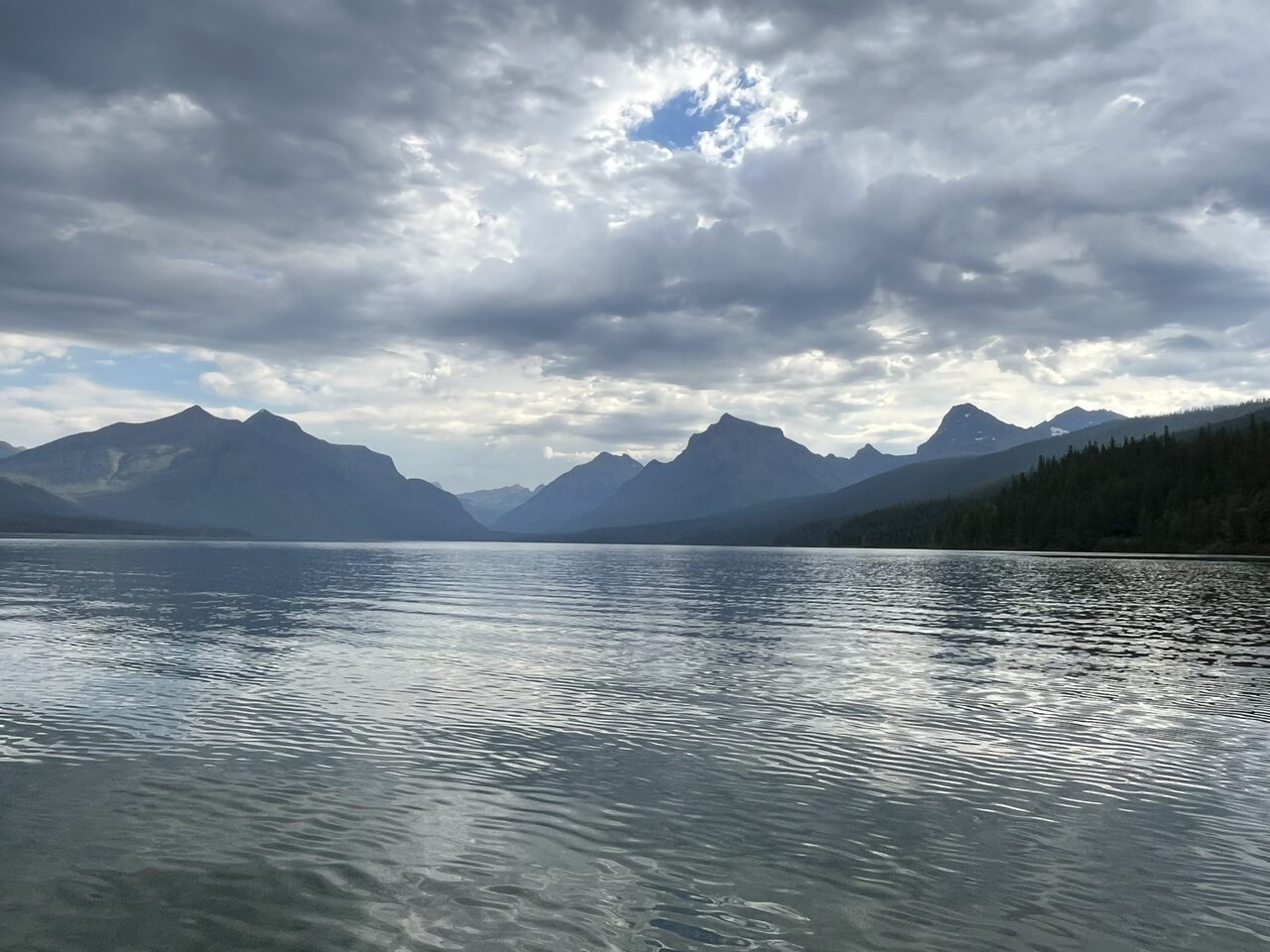 Lake McDonald and McDonald Creek in Glacier National Park, photographed from the water in July 2026