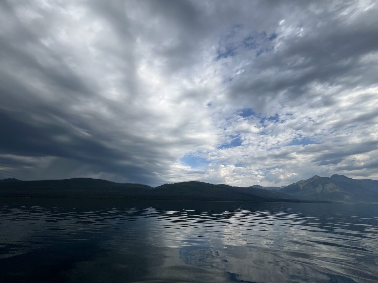 Lake McDonald and McDonald Creek in Glacier National Park, photographed from the water in July 2026