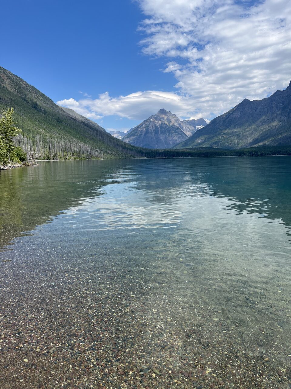 Lake McDonald and McDonald Creek in Glacier National Park, photographed from the water in July 2026